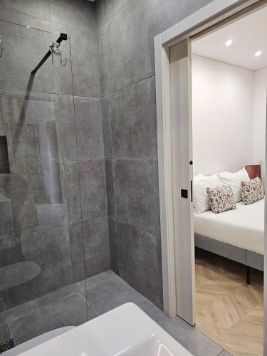 a bathroom with a shower and a bed in the background at City Center Terrace in Faro