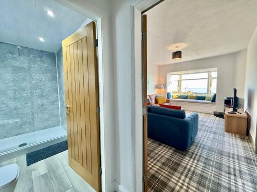a living room with a blue couch and a television at Lagoon View - Sea View- Pet Friendly - 2 Bed Apt - En-suite in Trearddur