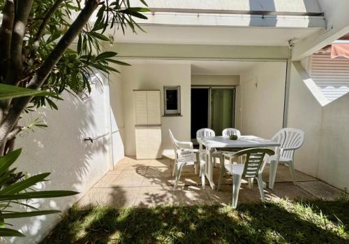 une table et des chaises assises sur une terrasse dans l'établissement Studio 4 personnes avec piscine proche plage, à La Grande Motte