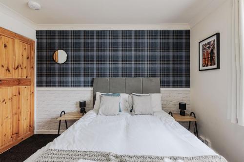 a bedroom with a bed with white sheets and pillows at Henry House in Hartlepool
