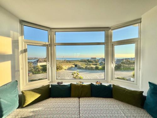 a living room with a couch and a large window at Lagoon View - Sea View- Pet Friendly - 2 Bed Apt - En-suite in Trearddur