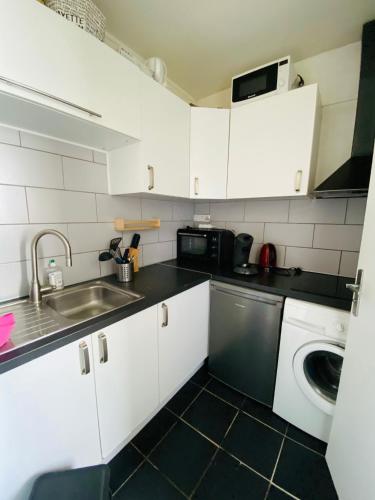 Il comprend une petite cuisine équipée d'un évier et d'un lave-vaisselle. dans l'établissement Appartement Colisée Champs Elysées, à Paris