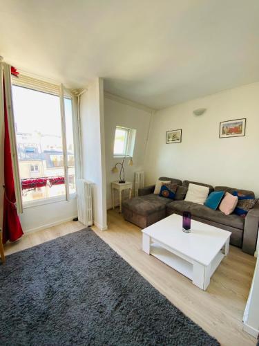 un salon avec un canapé et une table basse dans l'établissement Appartement Colisée Champs Elysées, à Paris