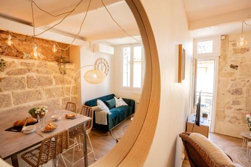 - un salon avec une table, un canapé et un miroir dans l'établissement La Salicorne, à Bouzigues
