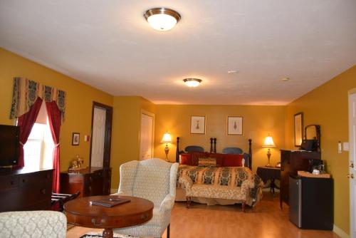 a bedroom with a bed and a couch and a table at Auberge Wild Rose Inn in Moncton