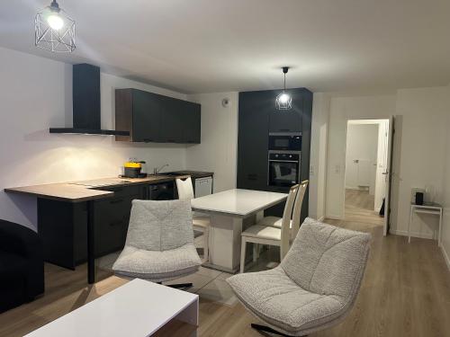 une cuisine avec une table et des chaises dans une pièce dans l'établissement Colombes - Logement entier 2 chambres - Salon, à Colombes
