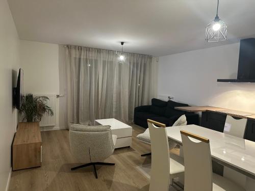 une cuisine et un salon avec une table et un canapé dans l'établissement Colombes - Logement entier 2 chambres - Salon, à Colombes