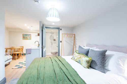a bedroom with a white bed with a green rug on it at The Willows Boutique Stays Central Whitby in Whitby