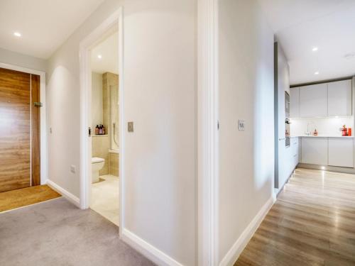 a hallway with white walls and a bathroom with a toilet at Beautiful Loft Apartment City Centre in Belfast