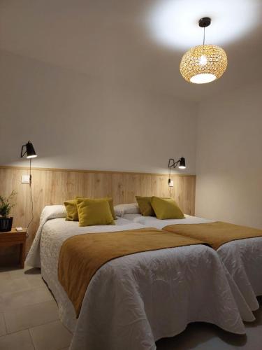 a bedroom with a large bed and a chandelier at Casa tía Satur in Consuegra