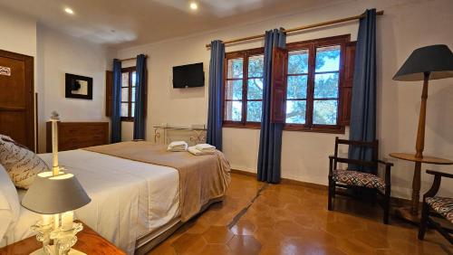 a bedroom with a bed and a chair and windows at Asis de Marratxinet Turismo de Interior in Marratxí 