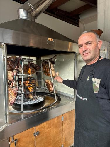 a man standing in front of an oven with food at Dictamus Homes in Magoulás