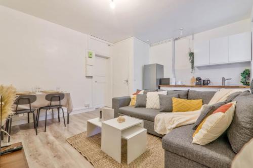 un salon avec un canapé et une table dans l'établissement La Pause Détente au pied du Stade de France, à Saint-Denis