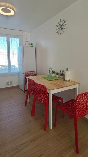 une cuisine avec une table, des chaises et un réfrigérateur dans l'établissement Petit cosy, à Quimper