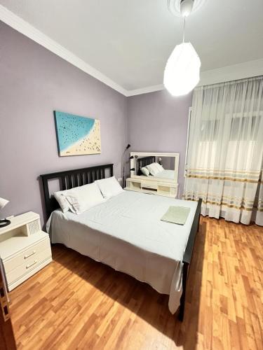 a bedroom with a large bed and a wooden floor at Sand Blue Nea Peramos in Néa Péramos
