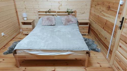 a bedroom with a bed in a wooden room at Dom wypoczynkowy Jelonek in Swolszewice Duże