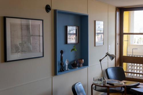 Cette chambre est dotée de murs bleus, d'une table et de chaises. dans l'établissement Le Corbusier Type B, à Marseille