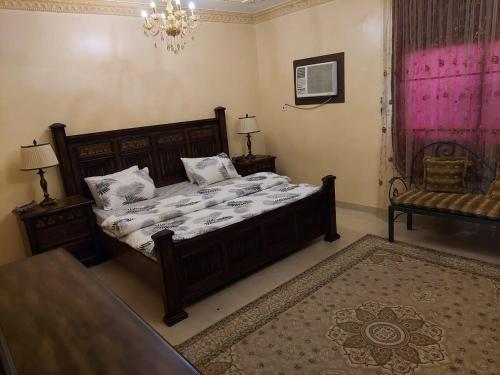 een slaapkamer met een bed, een tafel en een bank bij Pool House at Janabiyah in Al Janabīyah