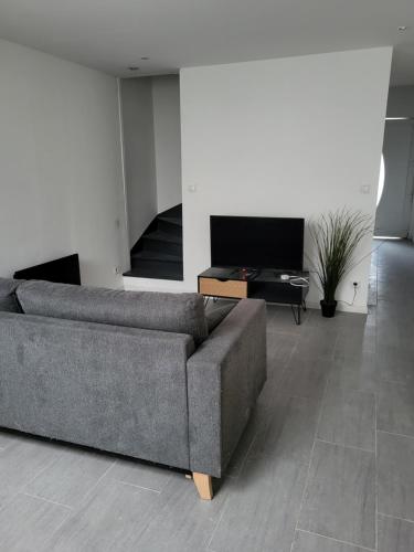 un salon avec un canapé et une table dans l'établissement La Tanière du Nord, à Lens