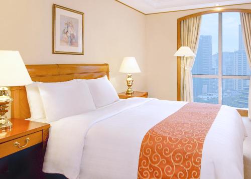 a hotel room with a large bed and a window at Richmonde Hotel Ortigas, Manila in Manila