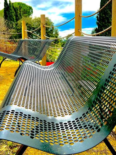 un banc métallique installé au-dessus d'une aire de jeux dans l'établissement Maison Joyeuseté, Cité de Carcassonne 7 min, Piscine 20m chauffée toute l'année, Clim, Parking, à Berriac