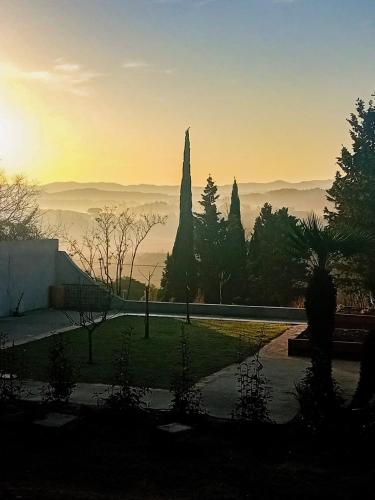 Elle offre une vue sur le jardin et le coucher de soleil en arrière-plan. dans l'établissement Maison Joyeuseté, Cité de Carcassonne 7 min, Piscine 20m chauffée toute l'année, Clim, Parking, à Berriac