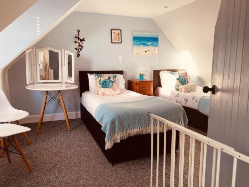 a small bedroom with two beds and a staircase at Driftwood in Gourdon