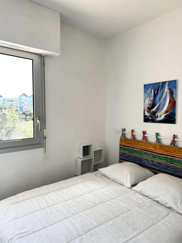 une chambre avec un grand lit et une fenêtre dans l'établissement Résidence Eugenie - T2 rénové 4 pers. en 1ère ligne, accès direct plage MAE-9664, à Arcachon