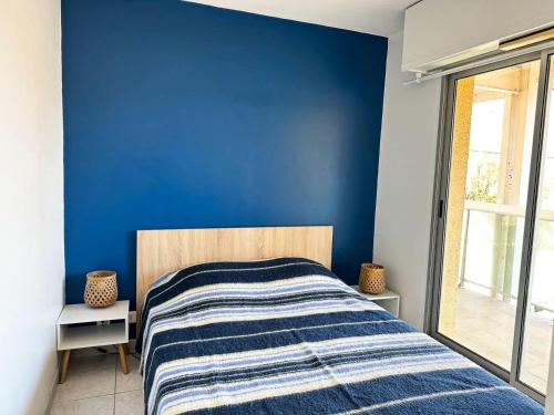 une chambre avec un mur bleu et un lit dans l'établissement Résidence La Croisette - Charmant T2 lumineux avec terrasse - Plage d’Eyrac MAE-9434, à Arcachon