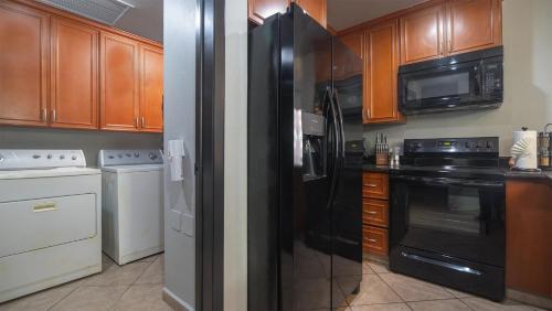 a kitchen with black appliances and wooden cabinets at Las Palomas Beach & Golf Resort in Puerto Peñasco
