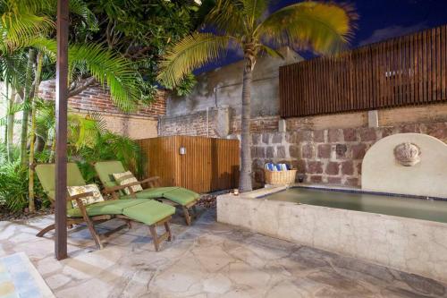 a swimming pool in a backyard with chairs and a table at Casa Abuelita: An exquisite, historic La Paz home in La Paz