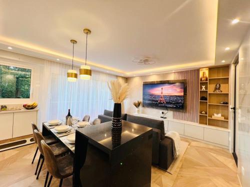 - un salon avec une table à manger et une télévision dans l'établissement Appartement luxueux Le Bon Marché Paris 6, à Paris