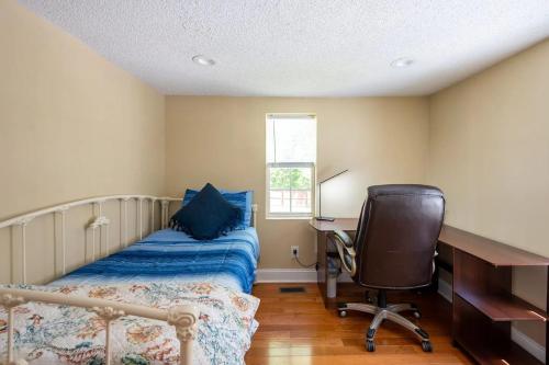 a bedroom with a bed and a desk and a chair at Modern 3-bedroom, big fence yard, Pets stay free in Durham