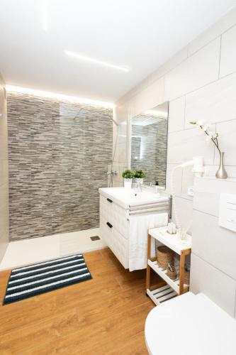 a white bathroom with a sink and a mirror at Villa Dani in Pollença
