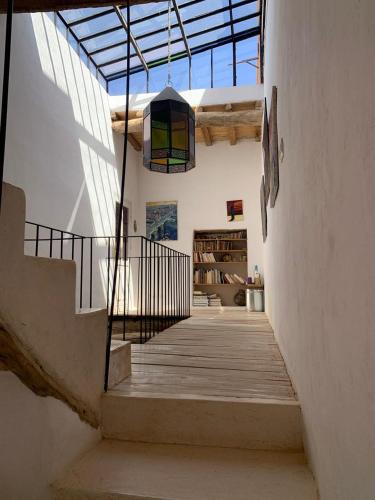 a hallway with stairs and a chandelier in a house at RIAD CHANT D'ETOILES tadighoust in El Hara