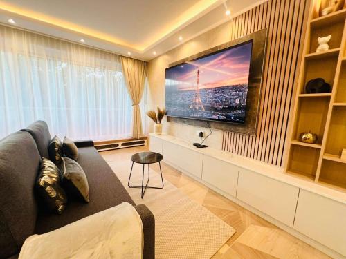 un salon avec un canapé et une télévision à écran plat dans l'établissement Appartement luxueux Le Bon Marché Paris 6, à Paris