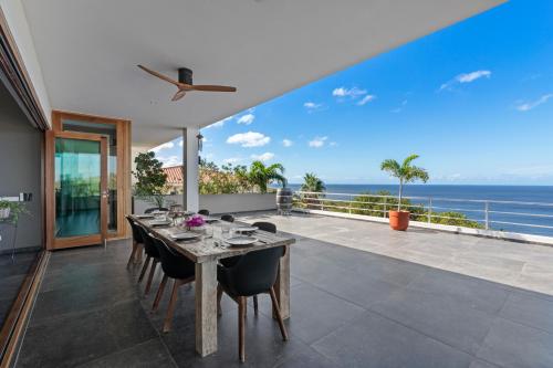 a dining room with a table and a view of the ocean at Villa Lahara with spectacular views in Dorp Soto