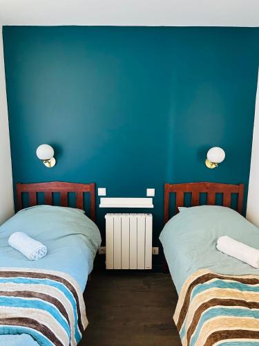 une chambre avec deux lits et un mur bleu dans l'établissement Appartement T2 avec piscine, à Deauville