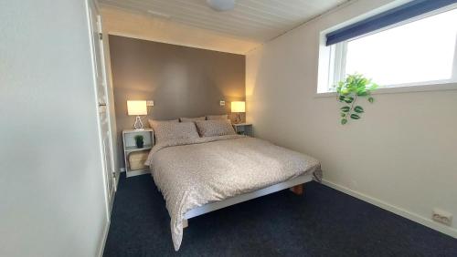 a bedroom with a bed with pillows and a window at Nelly's Home in Stavanger