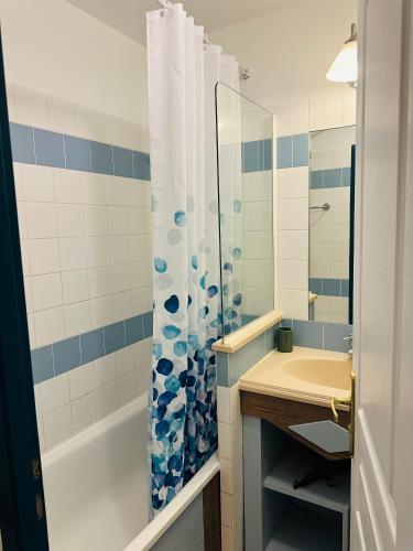 une salle de bain avec un rideau de douche et un lavabo dans l'établissement Appartement T2 avec piscine, à Deauville