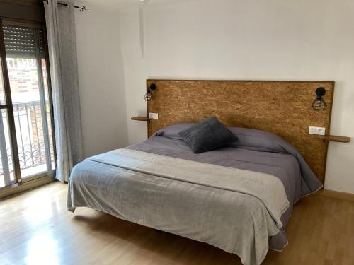 a bedroom with a large bed with a large headboard at Can Bareta in Xerta