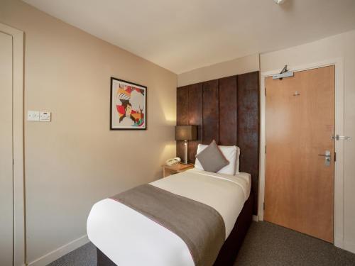a hotel room with a bed and a door at Brentwood Aberdeen City Centre near Union Street in Aberdeen