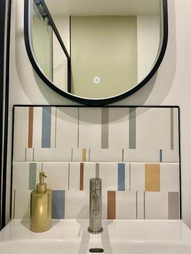 La salle de bains est pourvue d'un miroir et d'un lavabo. dans l'établissement Douceur Tourangelle - Entre Loire et centre ville, à Tours