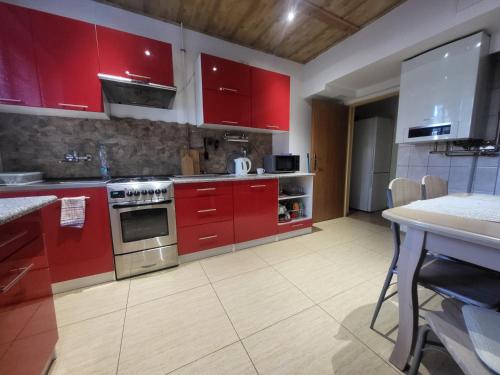 a kitchen with red cabinets and a table in it at Błękit Bałtyku in Łazy