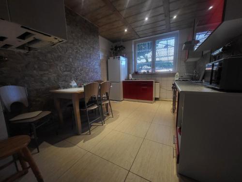 a kitchen with a table and chairs and a refrigerator at Błękit Bałtyku in Łazy