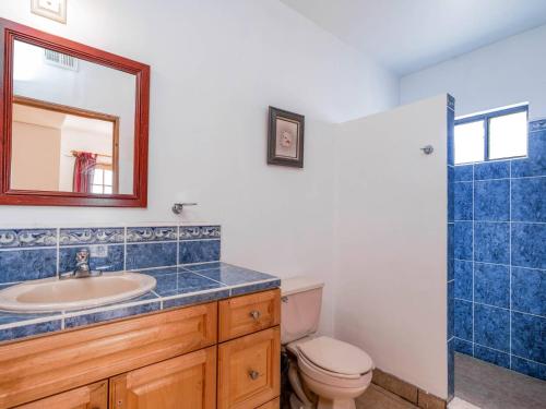 a bathroom with a sink and a toilet and a mirror at Casa Tilly El Dorado Ranch San Felipe Rental Home in Playa El Paraíso