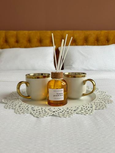 two jars of honey and chopsticks on a tray on a bed at Apartmani BOŽIČKOVIĆ in Palić