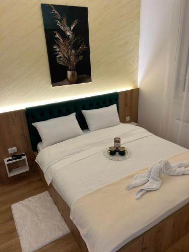 a bedroom with a large white bed with a plate on it at Apartmani BOŽIČKOVIĆ in Palić