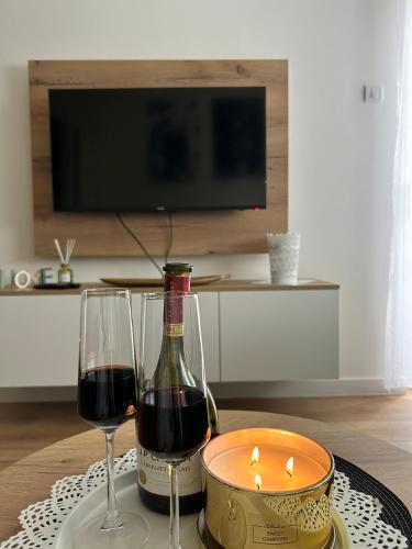 a table with a bottle of wine and two glasses at Apartmani BOŽIČKOVIĆ in Palić