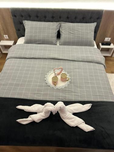 a bed with a pair of glasses and a bow tie at Apartmani BOŽIČKOVIĆ in Palić